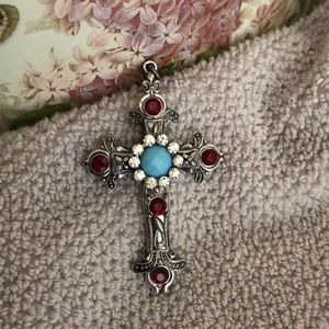 Silver cross w/ red, blue & silver rhinestones.
